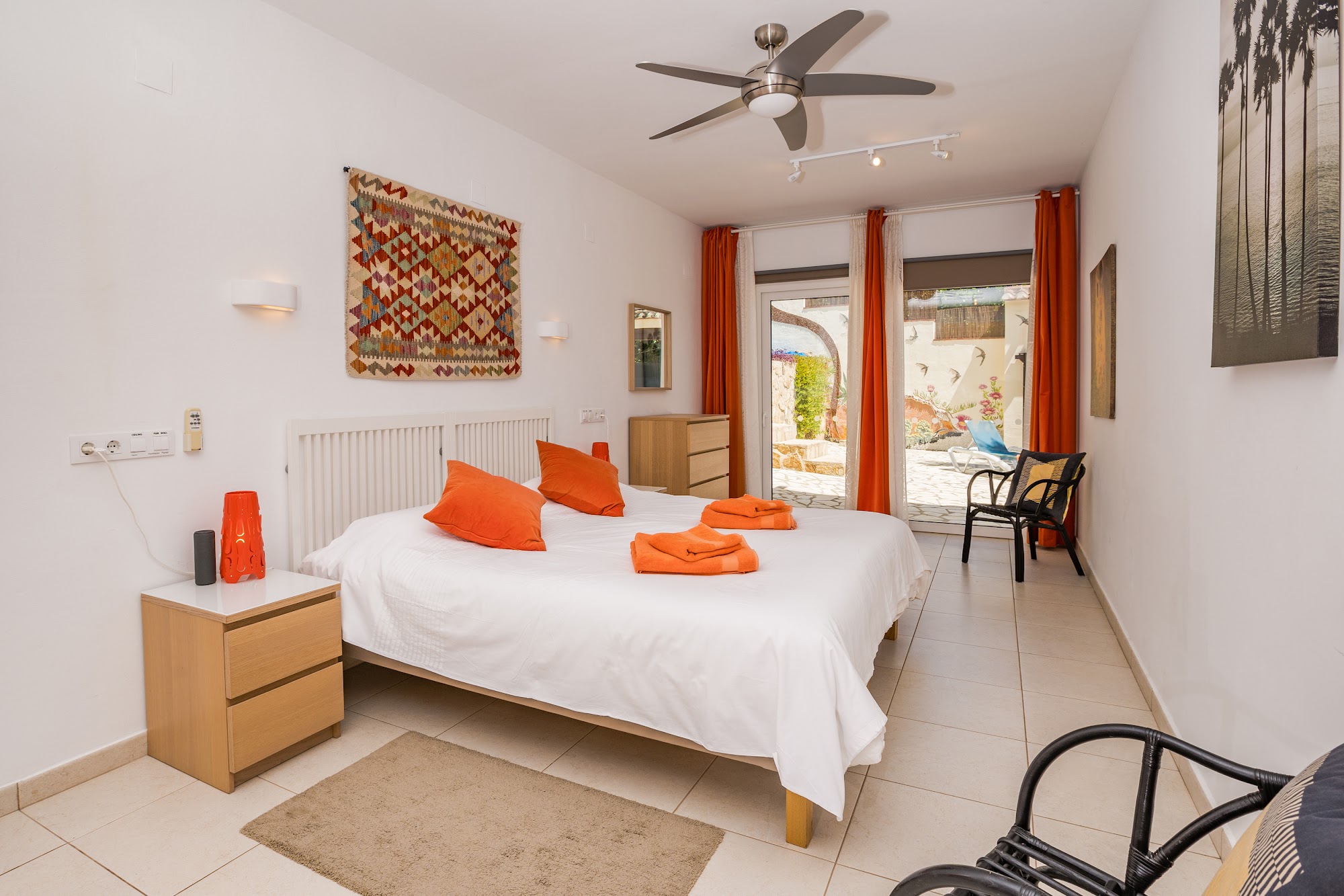 Double bed dressed with orange towels and pillows