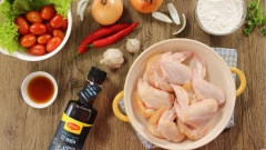 Cánh gà rửa sạch, để ráo nước, ướp với 1/2 muỗng canh nước mắm cho thấm gia vị. Rắc 10gr bột mì vào thịt gà sau đó trộn đều.