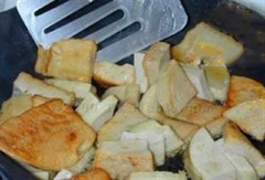Đun nóng 2 muỗng canh dầu ăn, cho giò lụa vào chiên sơ cho cháy xém các mặt. Trong tô nhỏ, trộn đều 1 muỗng canh đường, 2 muỗng canh nước mắm, 2 muỗng canh nước cốt chanh, hành tây, ngò rí và ớt cắt nhỏ.