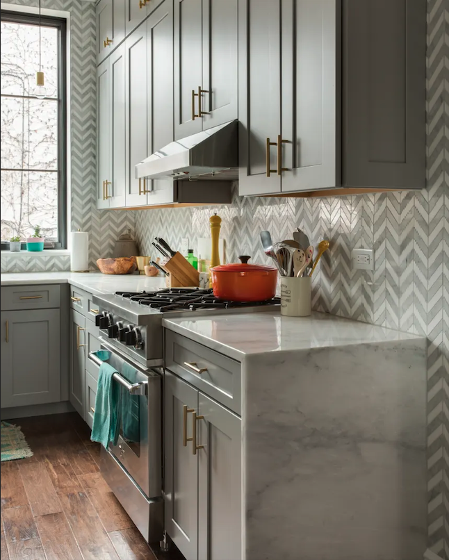Blue kitchen with professional range and marble countertops