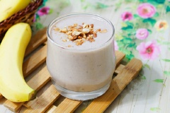 Hỗn hợp sinh tố chuối sữa đã xay xong thì rót ra ly, rắc thêm 1 ít lạc rang chín giã dập lên trên để thưởng thức.