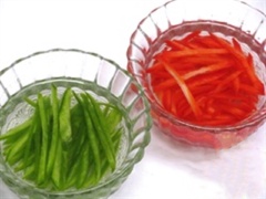 Ớt chuông chẻ đôi, bỏ hạt, thái sợi nhỏ rồi ngâ vào nước lạnh cho đỡ bị hăng. Chả lụa thái sợi. Sau khi đã cắt phần ruột đỏ để sang một bên thì gọt bỏ phần vỏ xanh đi, chỉ lấy phần cùi trắng rồi cũng thái nhỏ như que tăm.