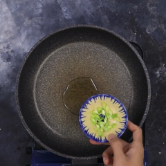 Phi thơm hành lá cùng 1 tbsp (muỗng canh) dầu thực vật, tiếp đến cho cà rốt vào xào sơ 3 phút.