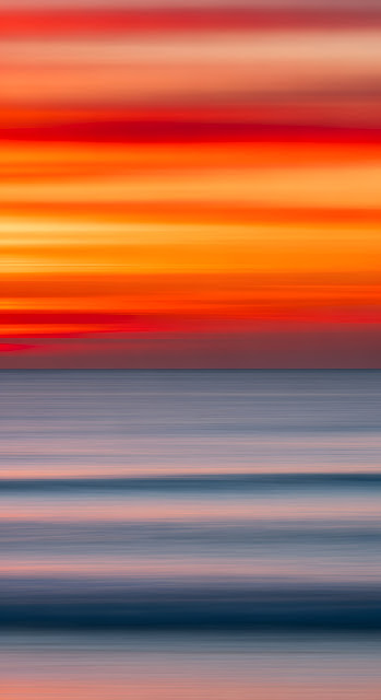 Abstract Intentional Camera Movement Photo of Vibrant Orange Sunset Over Blue Ocean - Free mobile Wallpaper