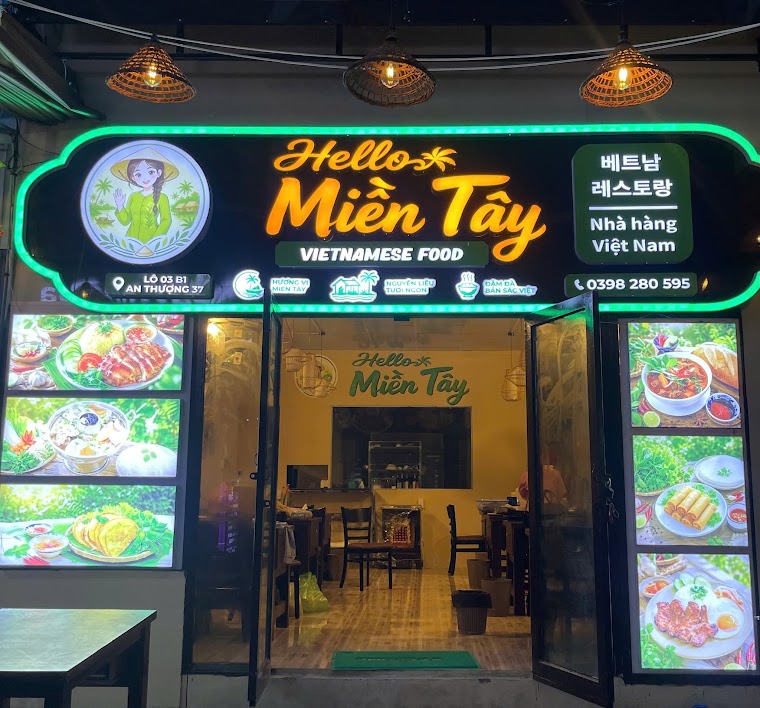 현지 식당 야간 외관 — 간판에 베트남어와 한국어가 함께 올라가 있지만 두 표기가 향하는 손님은 다릅니다