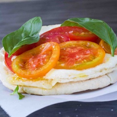 Rắc dầu olive muối và tiêu lên bánh, tiếp theo xếp phô mai và cà chua, lên bánh mì. Bắc chảo lên bếp và đun nóng khoảng 3 phút ở lửa vừa, bạn thả thử 1 giọt nước vào, nước lập tức bị đun nóng và bốc hơi có nghĩa là chảo đã được, vặn nhỏ lửa rồi kéo léo để bánh pizza lên.
