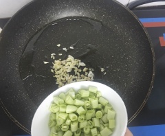 Rửa sạch đậu cô ve (đậu que), tước xơ rồi cắt khúc khoảng 1cm. Bắc chảo nóng, phi thơm 5gr tỏi băm và 5gr gừng băm nhỏ rồi cho đậu cô ve vào xào đều.