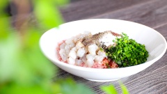 Chuẩn bị nhân hoành thánh: cho 500gr thịt băm, 200gr tôm tươi đã lột vỏ và cắt hạt lựu, 100gr lá hẹ cắt nhỏ, 15gr đường, 15ml nước tương, 15ml dầu mè, 15ml nước lọc, 15ml dầu ớt, 3gr muối tiêu vào chung một tô, trộn đều và ướp trong 15 phút.