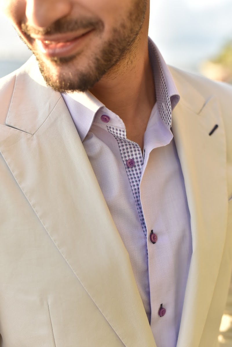 Tailor measuring a suit jacket on a client in a Miami fitting room