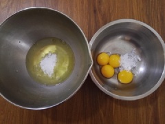 Tách lòng đỏ trứng và trứng ra khỏi trứng và đặt vào hai thố. Sau đó cho 20g đường trắng vào lòng trắng và 13g đường trắng vào lòng đỏ trứng. Tiếp đến, thêm 22ml nước tinh khiết vào thố lòng đỏ trứng và đánh tan đều.