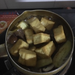 Phi dầu và ba rô, sau đó đổ cà tím và nấm hương vào xào sơ, tiếp đến đổ nước sôi ngập cà và nấm. Nước sôi thả khuôn đậu vào và nêm gia vị cho vừa ăn.