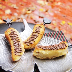 Khi chuối ráo dầu, rưới thêm siro chocolate đen lên trên và rắc cả một ít đậu phộng rang nếu bạn thích.