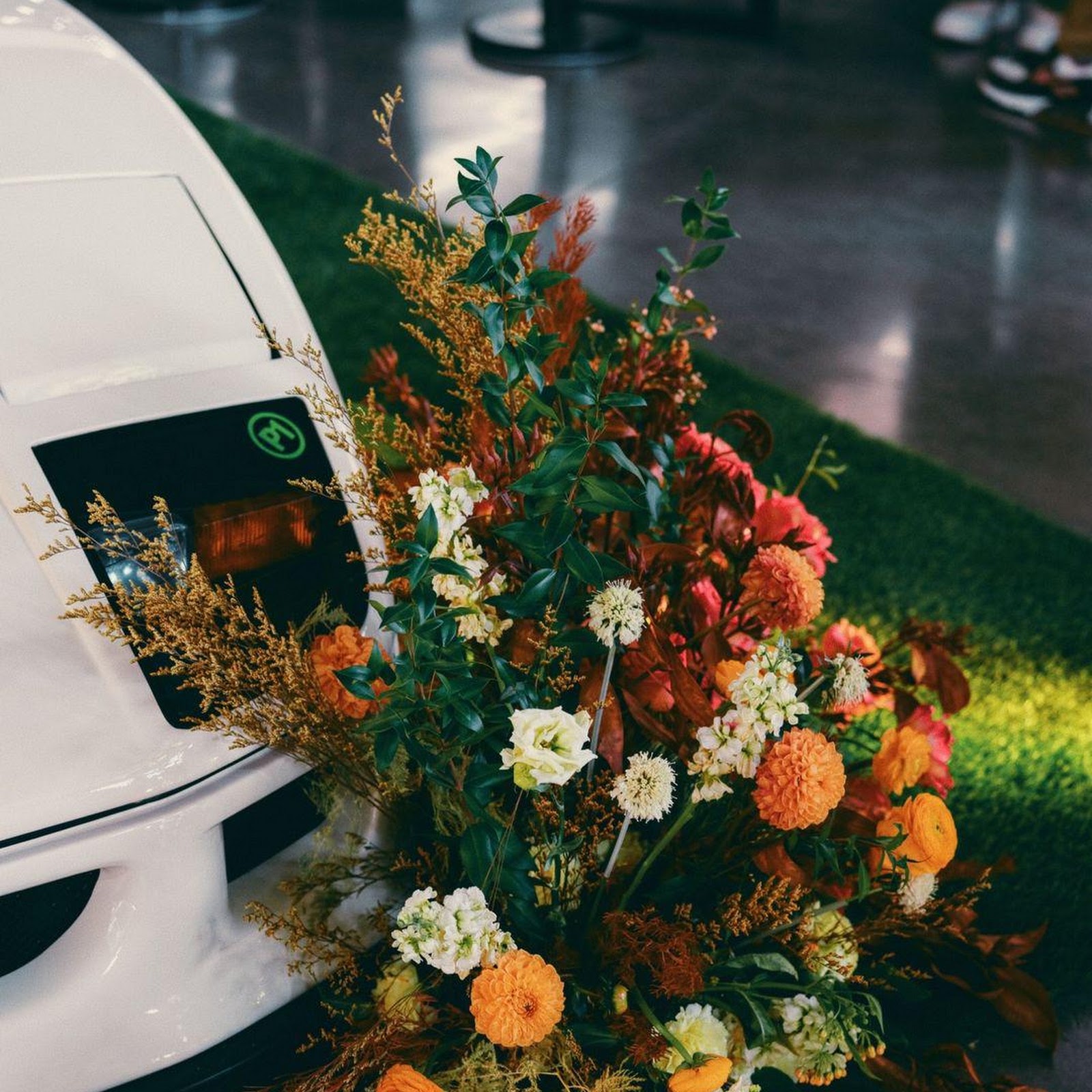 Download Floral Display Next to White Car Full HD iPhone