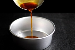Chế chút nước vào khay nướng cho vào lò làm nóng ờ 200 độ C. Làm caramel: cho 100g đường, 2 muỗng nước vào nồi vừa nấu vừa khuấy đến khi đường có màu cánh gián đẹp thì tắt bếp rồi chế vào khuôn tròn lớn, trán đều khuôn. Làm espresso: hạt cà phê xay nhuyễn rồi cho vào nồi cùng 363ml sữa tươi nguyên kem (Half-Half) và nấu trên bếp đến khi sôi thì tắt bếp, để nguội. Cho 4 lòng đỏ, 2 quả trứng, sữa đặc vào tô, đánh đến khi mịn rồi từ từ chế hỗn hợp espresso vào qua rây lọc.