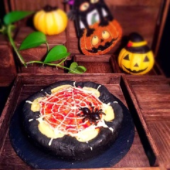 Bánh pizza đen Halloween được tạo hình như một động nhện. Đây là món ăn mặn trông không kinh dị lắm nhưng cũng phủ hợp với không khí của ngày lễ hoa trang Halloween rồi nhé!