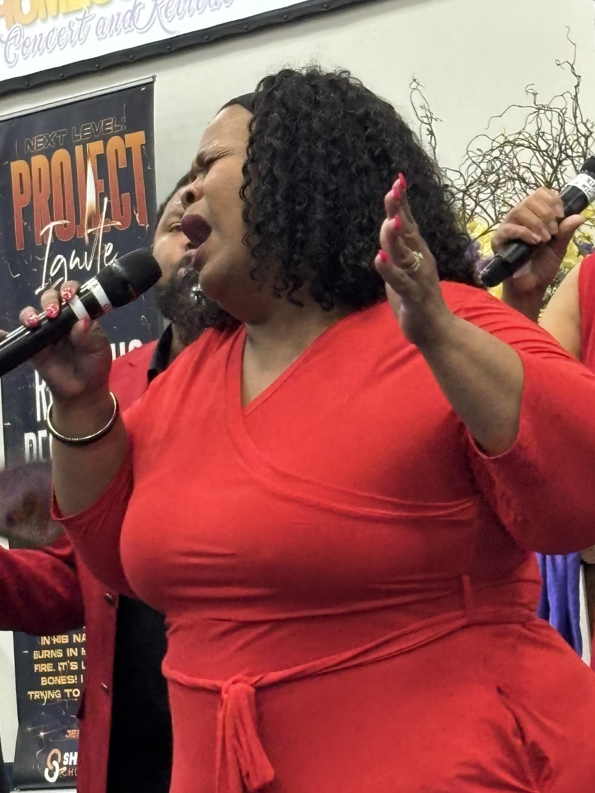 Passionate female vocalist in red praising during Homecoming Concert at Sharpe Road Church of Christ