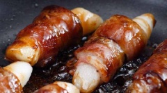 Đun nóng 3 muỗng canh dầu ăn trong chảo đáy phẳng, cho thịt xông khói cuộn bánh gạo vào chiên chín vàng. Sau đó, thêm sốt yakiniku vào và đun thêm khoảng 2 phút nữa thì tắt bếp.