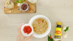 Pha nước mắm cho món bún: chuẩn bị 1 chiếc tô, cho vào đây 2 muỗng canh nước mắm Maggi, 2 muỗng canh nước lọc, 3 muỗng canh đường và 1 muỗng canh bột chanh Maggi, khuấy đều cho hỗn hợp nước mắm hòa quyện vào nhau. Tiếp theo cho thêm 5gr tỏi băm, 5gr ớt sừng băm rồi khuấy đều là hoàn tất phần nước mắm.