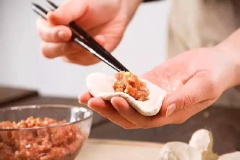 Ngắt từng miếng bột viên tròn rồi ấn dẹt, cho phần nhân thịt đã trộn vào giữa rồi bọc kín lại. Nhẹ nhàng ấn dẹt chiếc bánh.