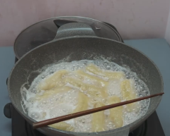 Rim chuối cho sôi, để đũa đậy nắp để không bị tràn. Rim chuối đến khi cạn nước rồi bật lửa nhỏ để chuối thêm đỏ. Chỉ cần hồng đỏ như hình là được. Thời gian rim chuối khoảng 40~50 phút.