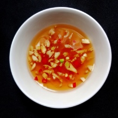 Pha nước trộn bún theo tỷ lệ: 3 thìa nước lọc; 1,5 thìa nước cốt chanh; 1,5 thìa đường, 2 thìa nước mắm rồi trộn đều. Tiếp đó thêm tỏi ớt băm nhỏ vào hòa chung là xong. Cho bún ra tô, xếp rau sống vào, thêm thịt đã xào lên trên, rắc thêm một ít lạc giã rối. Cuối cùng chan nước trộn bún rồi trộn đều là xong.