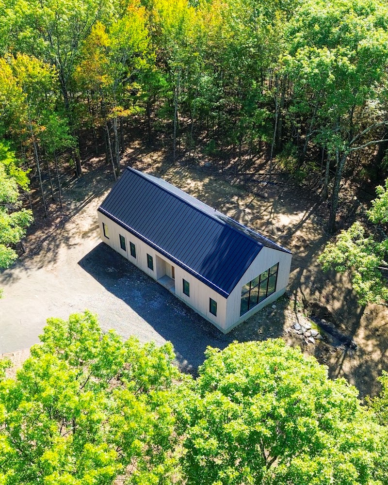 Overhead drone shot of modern metal-roof home in the woods — drone photography Hudson Valley