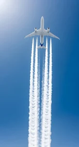 Commercial Jet Leaving Four Distinct Contrails in Blue Sky