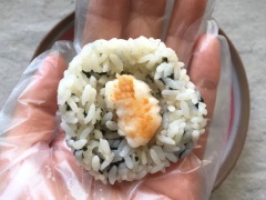 Giữ nguyên chảo, thêm chút dầu, cho cà rốt vào xào với chút muối đến khi chín mềm. Xào tương tự với dưa leo. Rong biển xắt nhỏ. Cho cơm vào tô trộn với rong biển, nước sốt salad, giấm trộn sushi, dầu mè cho thật đều. Sau đó lấy một chút cơm cho vào lòng bàn tay rồi cho tôm xào vào giữa và bọc lại. Tiếp theo lăn viên cơm qua lòng đỏ trứng hay cà tốt, dưa leo đều được. Vậy là hoàn thành món cơm nắm rồi đó.