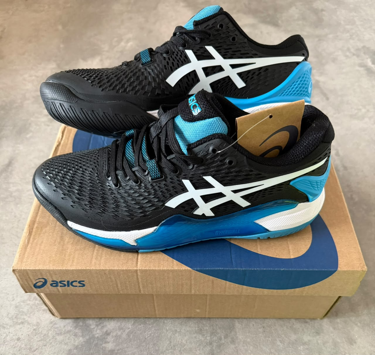 ASICS RESOLUTION 9 NEGRA CON CELESTE LOGO BLANCO