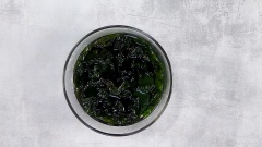 Sơ chế nguyên liệu: Ngâm nở 15gr rong biển khô với 1/2 muỗng canh muối và 200ml nước. Xúc xích cắt thành từng miếng vừa ăn. Hành boaro cắt nhỏ. Nấu chín mì cay Hàn Quốc trong 2 phút.
