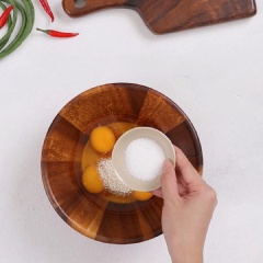 Đập 4 quả trứng gà nêm cùng 1 muỗng canh hạt nêm, 1 muỗng canh đường, 1 muỗng canh nước mắm. Dũng đũa đánh tan hỗn hợp trứng.