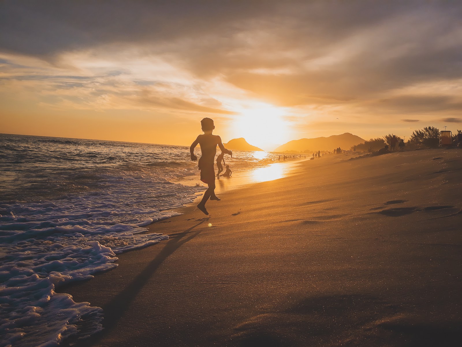 Boy running beach sunset. Travel decelerate climate crisis, Tourism carbon emission, carbon eco trip. CarbonEthics Indonesia