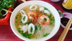 Cuối cùng chần sơ giá đỗ, cho vào tô. Xếp hủ tiếu vào rồi cho lên trên cá viên, tôm, mực. Múc nước dùng rưới lên hủ tiếu hải sản. Rắc thêm ít hẹ, hành lá, hành phi. Khi ăn có thể vắt thêm chút chanh, rưới sa tế để hủ tiếu hải sản thêm đậm đà, cay nồng nhé!