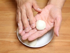 Vo tròn các phần bột nhỏ rồi ấn dẹt, thêm một ít nhân đậu đỏ vào trong, vo tròn lại.