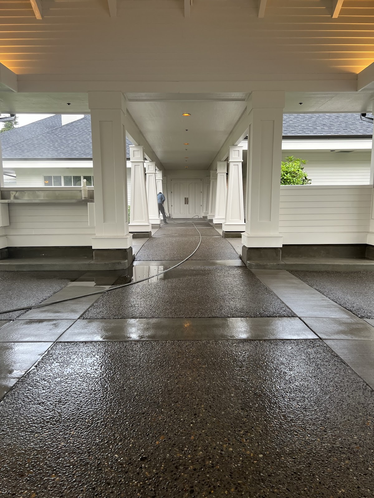 Freshly pressure washed commercial breezeway with stone columns in Portland Oregon