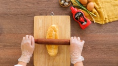 Bật lò nướng trước khoảng 10 phút. Dùng cây cán bột đập dập ổ bánh mì, phết mỡ hành lên đều mặt, tiếp theo phết sốt sa tế tôm lên. Tiếp theo là xếp xúc xích cắt xéo thành bông hoa rồi đập quả trứng cút làm nhụy hoa, đem nướng khoảng 10 phút với nhiệt độ 200 độ C.