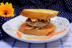 Cho lát bánh mì ra đĩa, thêm một ít dưa chua, cà rốt rồi đặt miếng thịt chiên lên trên, tiếp đó thêm một ít dưa và đặt lát bánh mì còn lại lên trên là xong. Khi ăn có cũng có thể rưới thêm một ít tương ớt.