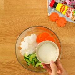 Chuẩn bị đồ chua: Tỉa hoa, thái lát mỏng 50gr củ cải trắng và 50gr cà rốt. Cắt đôi, bỏ hạt, thái lát dày 0,5cm 50gr dưa leo. Bóp sơ 3 loại rau củ với 3gr muối và 30gr đường, để yên 15 phút cho ngấm.