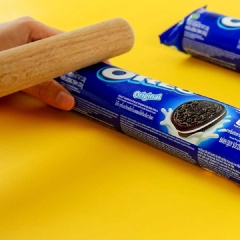 Lấy 4 cây bánh Oreo dùng cối đập nhuyễn, cắt đôi rồi xếp đứng túi bánh ở trong tô.
