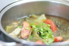 Đun nhỏ lửa tới khi dưa đạt độ mềm yêu thích thì thêm hết cà chua còn lại và nồi, đun thêm 5 phút nữa thì tắt bếp. Rắc rau ngò vào.