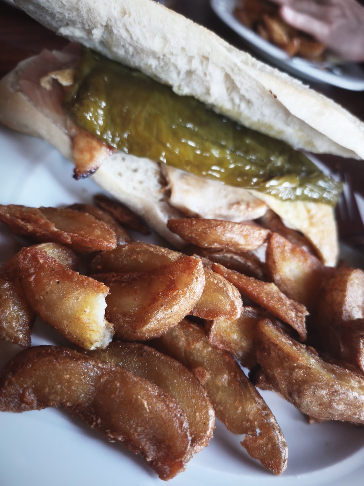 Serranito sandwich served with chips at Restaurante Mirlo Blanco in Zufre.