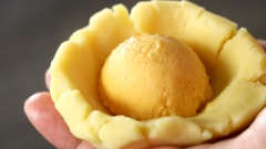 Để làm phần nhân của bánh trung thu lava, ngoài nhân trứng muối đang được làm đông ta chuẩn bị thêm 20 viên nhân đậu xanh dẻo, mỗi viên nặng 50gr (nhân đậu xanh có thể dễ dàng mua ở các cửa hàng bán dụng cụ nguyên liệu làm bánh hoặc những khu chợ lớn). Nhân trứng muối chảy sau khi làm đông, lấy ra khỏi khuôn. Dàn từng viên nhân đậu xanh ra thành miếng dẹt đủ bao bọc được nhân trứng muối, cho nhân trứng muối chảy vào rồi bọc lại thành những viên tròn.