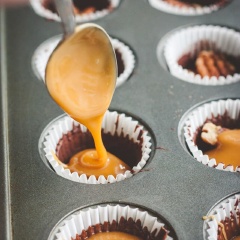 Làm lạnh cho chocolate đông lại, gắn hạt hồ đào lên. Bạn cho kẹo caramel vào tô chịu nhiều cùng heavy cream, quay khoảng 30 giây, sau đó trộn thật đều, cho vào lấp đầy hạnh hồ đào. Đun chảy lượng chocolate còn lại rồi phủ lên phần caramel.