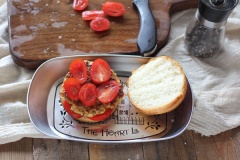 Cắt đôi bánh mì theo chiều ngang, xếp lên ít lát cà chua. Đặt biến thịt chiên lên, xếp lên tiếp 1 lớp cà chua rồi đặt nửa bánh mì còn lại lên trên cùng nữa là hoàn tất.