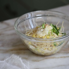 Cho giá vào tô, thêm vào hẹ, 1/2 muỗng cà phê tỏi băm, 2 muỗng canh dầu mè, 1/2 muỗng cà phê nước tương, 1/4 muỗng cà phê muối và 1 muỗng cà phê mè trắng rang, trộn đều lên.