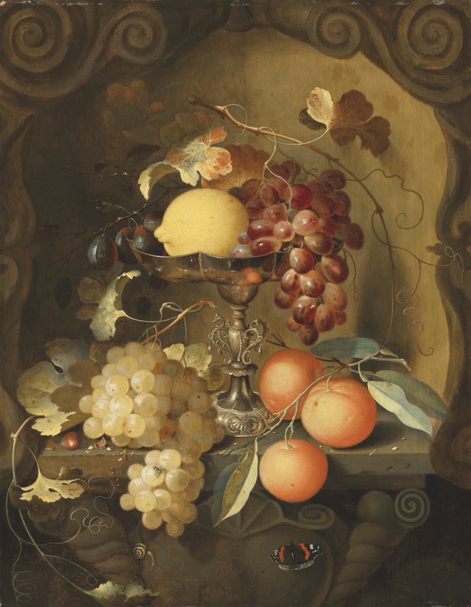 Grapes and a lemon on a tazza with oranges on a ledge in a sculpted stone niche