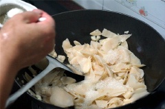 Phi thơm tỏi băm với 2 muỗng canh dầu ăn, cho măng vào xào trên lửa vừa. Nêm 2 muỗng cà phê đường, 1/2 muỗng cà phê muối và 1 muỗng cà phê hạt nêm vào đảo đều cho măng mềm. Cho ra đĩa để riêng.