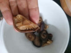 Cho nấm đông cô vào tô với 1 ít nước, ngâm nấm 20 phút cho nấm nở mềm. Nấm nở, xả nước lại nhiều lần cho sạch. Nếu tai nấm to thì cắt nắm làm đôi như hình.