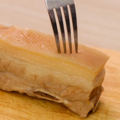 Sau đó cho thịt ra ngoài thớt, dùng nĩa xăm nhẹ trên da (để khi chiên da được giòn hơn). Ướp 30 phút thịt ba chỉ với 1/2 muỗng canh muối, 1/2 muỗng canh hạt nên, 1/2 muỗng canh tiêu, sau đó dựng đứng thịt lên, vắt nước cốt chanh lên phần da.