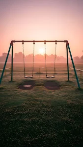 Empty Swing Set at Sunrise with Morning Fog